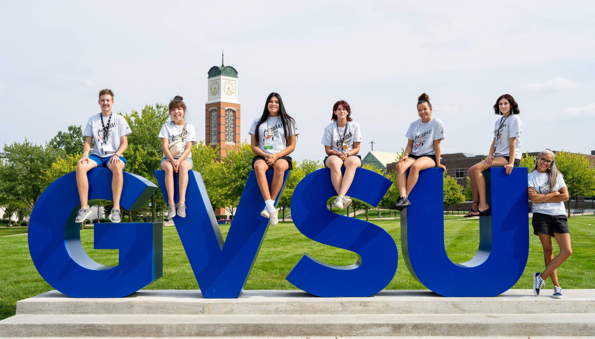 Students sitting on large GVSU letters on the Valley Campus
